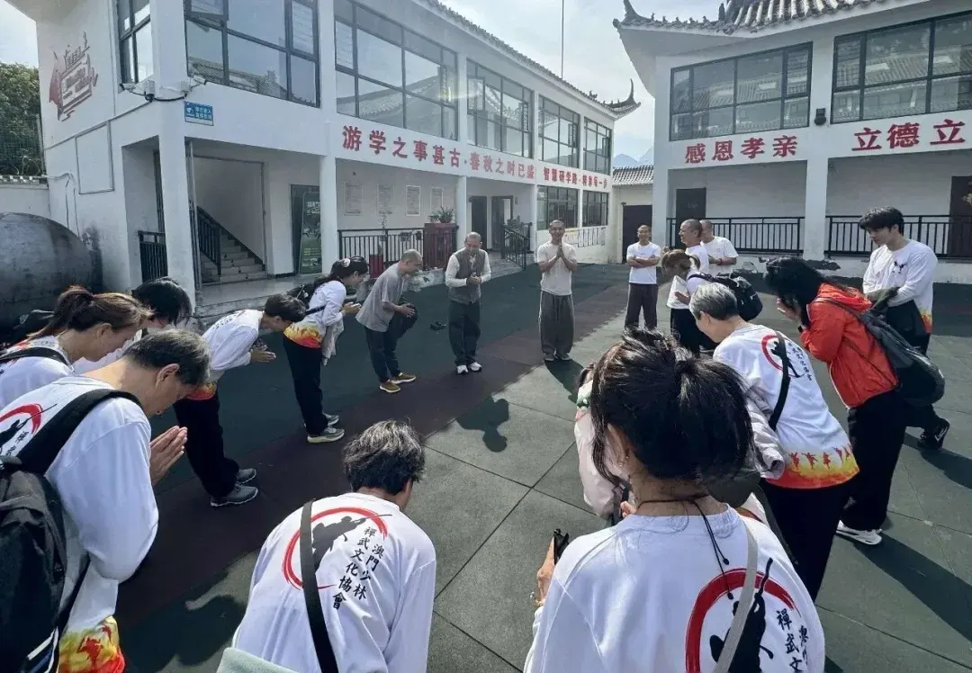 Macao students and Shaolin Zhongwu masters greeting each other with the fist and palm salute