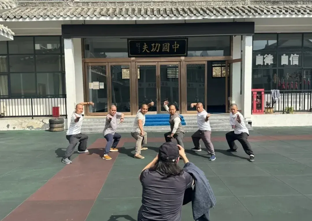 Students posing kung fu stances in front of the China Kung Fu plaque