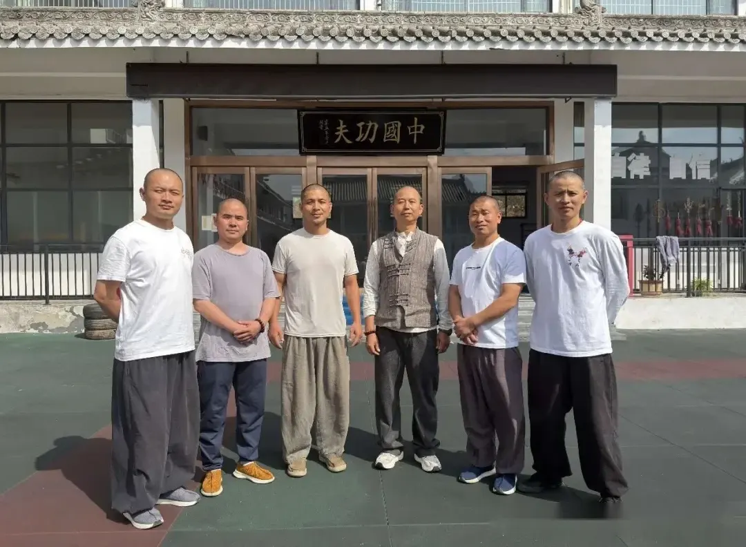 Masters of both centers taking a group photo at the Shaolin Zhongwu entrance
