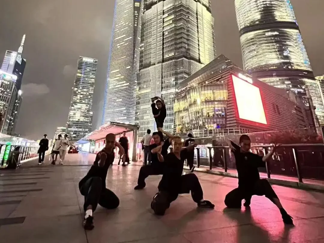 Young students forming a stacked kung fu pyramid by the Huangpu River