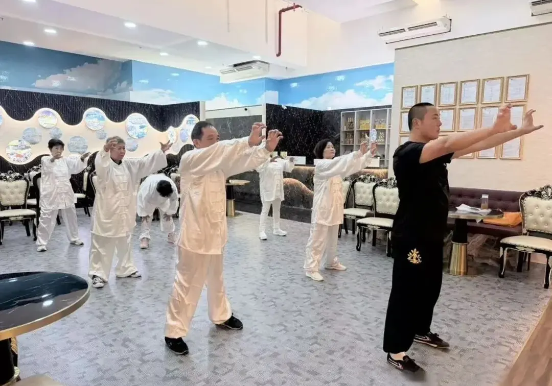 Coach and students practicing movements together at the Shaolin Cultural Center hall in Singapore