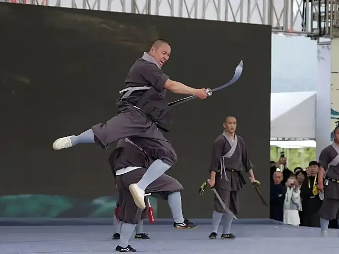 Shaolin Zhongwu student leaping with broadsword during opening performance