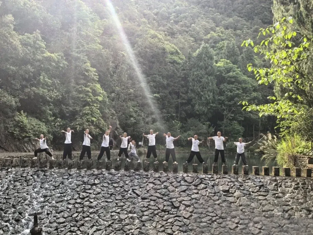 Shaolin Zhongwu students posing kung fu stances on the ancient weir stones